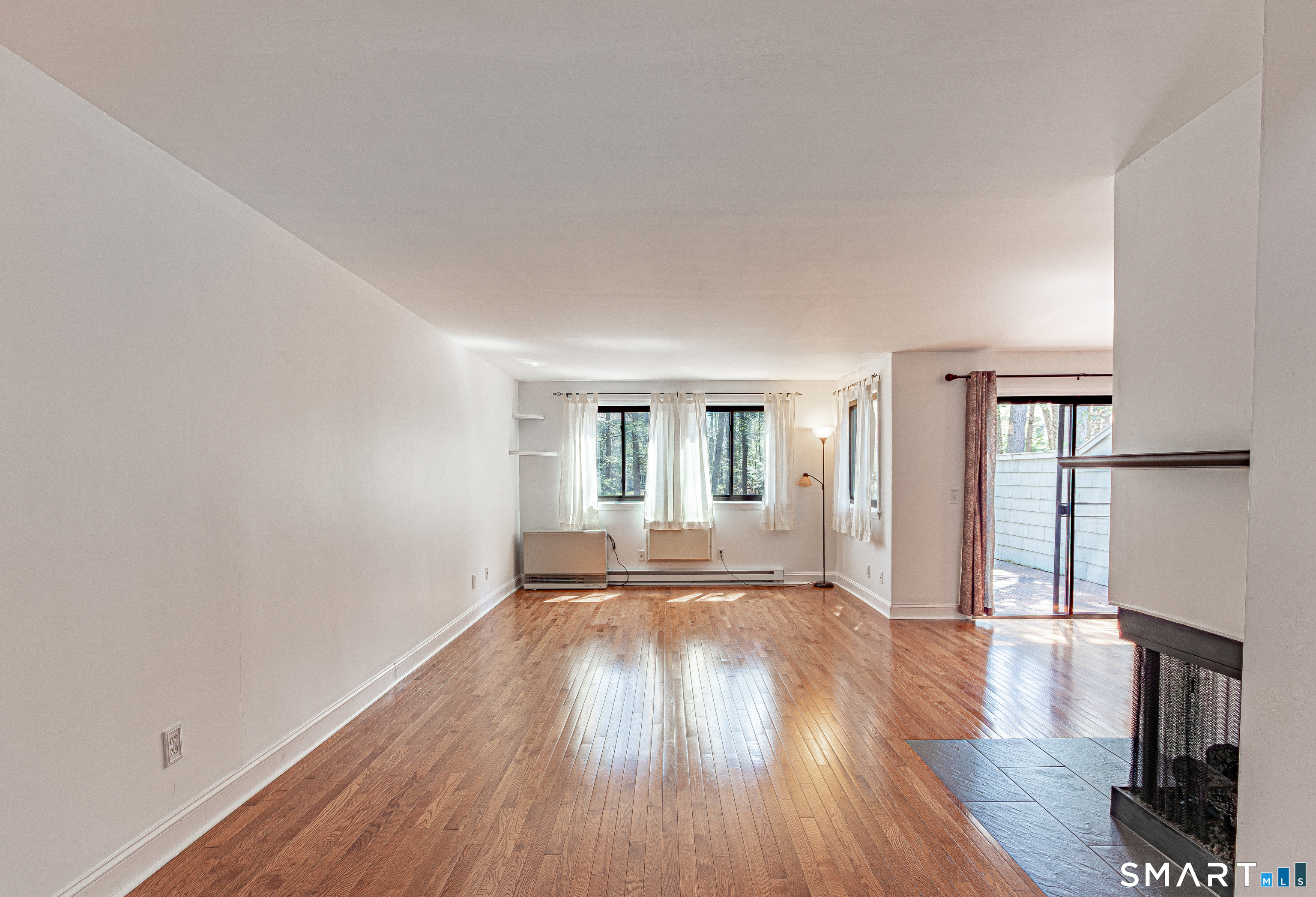 127 Old Farms Road, Unit 127 Torrington, CT 06790 - Photo 8 of 32 a view of an empty room with wooden floor and a window