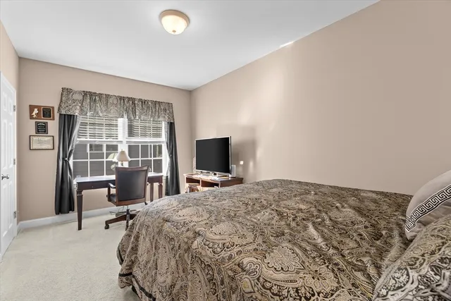 a bedroom with a bed and a flat tv screen next to a window