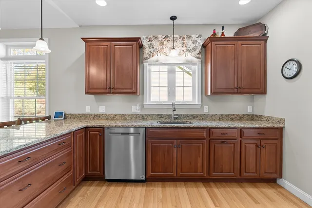 a kitchen with stainless steel appliances granite countertop wooden cabinets a sink and dishwasher
