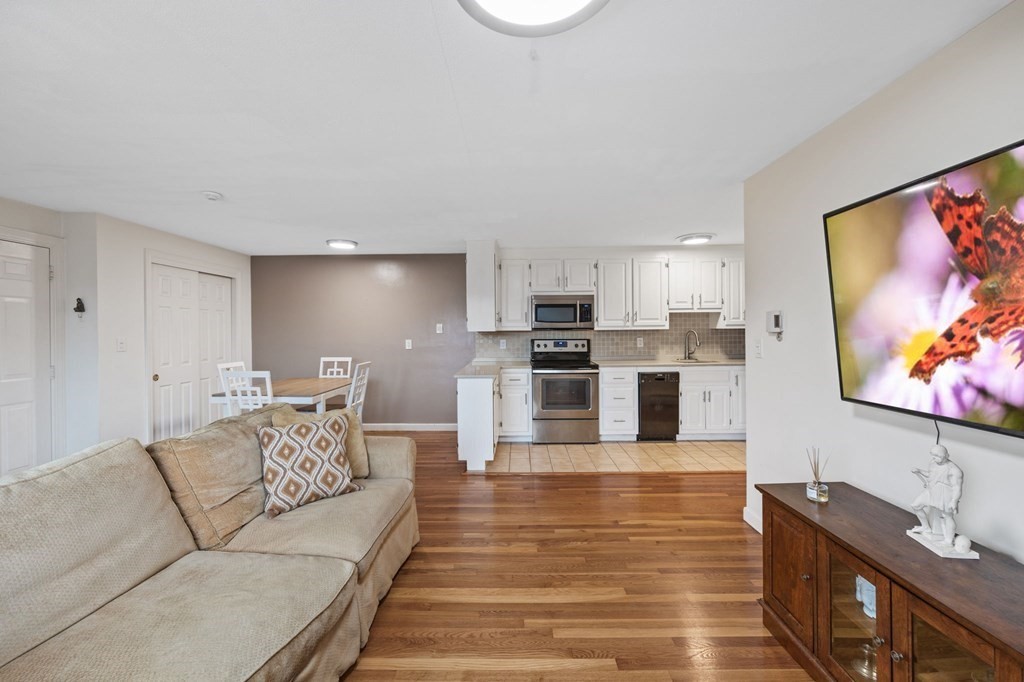 224 School Street, Unit 10 Walpole, MA 02081 - Photo 11 of 41 a living room with furniture and kitchen view with wooden floor