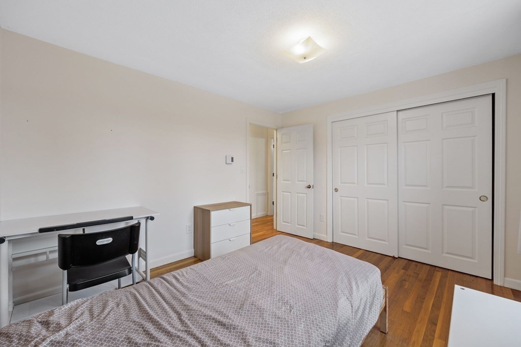 224 School Street, Unit 10 Walpole, MA 02081 - Photo 19 of 41 a bedroom with a bed and wooden floor