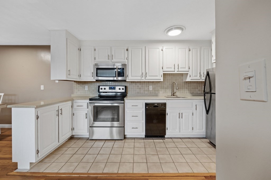 224 School Street, Unit 10 Walpole, MA 02081 - Photo 2 of 41 a kitchen with a stove top oven sink and cabinets