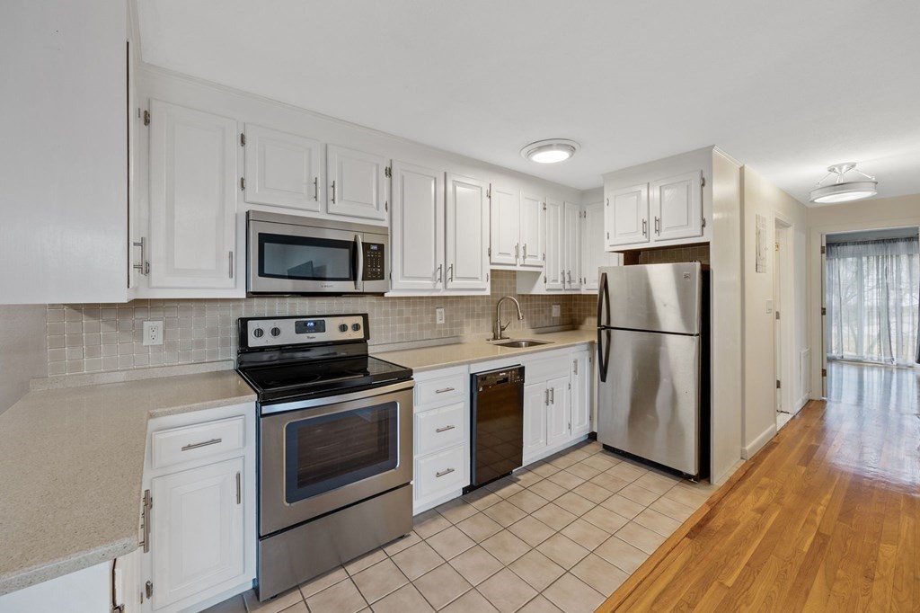 224 School Street, Unit 10 Walpole, MA 02081 - Photo 3 of 41 a kitchen with white cabinets stainless steel appliances and a refrigerator