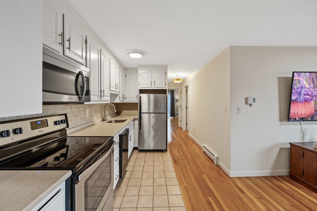 224 School Street, Unit 10 Walpole, MA 02081 - Photo 4 of 41 a kitchen with stainless steel appliances a refrigerator sink and microwave