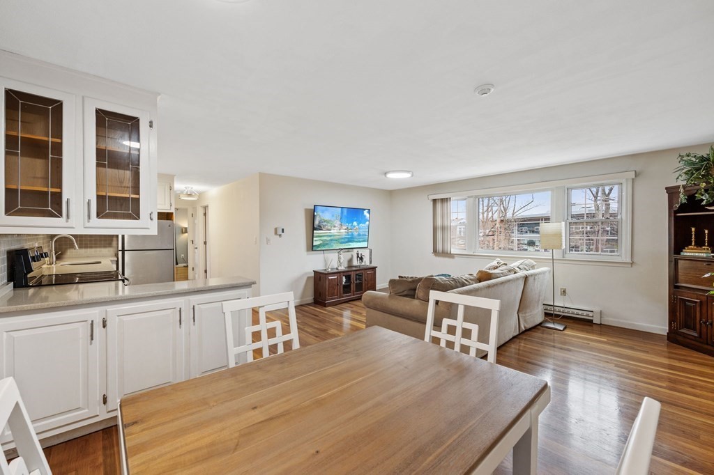 224 School Street, Unit 10 Walpole, MA 02081 - Photo 7 of 41 a large living room with stainless steel appliances granite countertop a couch wooden floor and a window