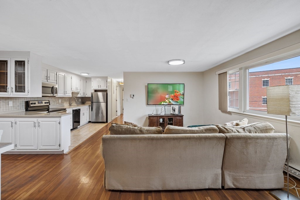 224 School Street, Unit 10 Walpole, MA 02081 - Photo 8 of 41 a living room with furniture and a flat screen tv