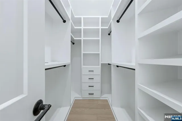 a view of walk in closet with empty racks