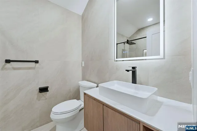 a bathroom with a sink a toilet and mirror