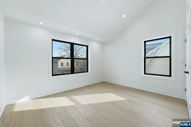 an empty room with windows and ceiling fan