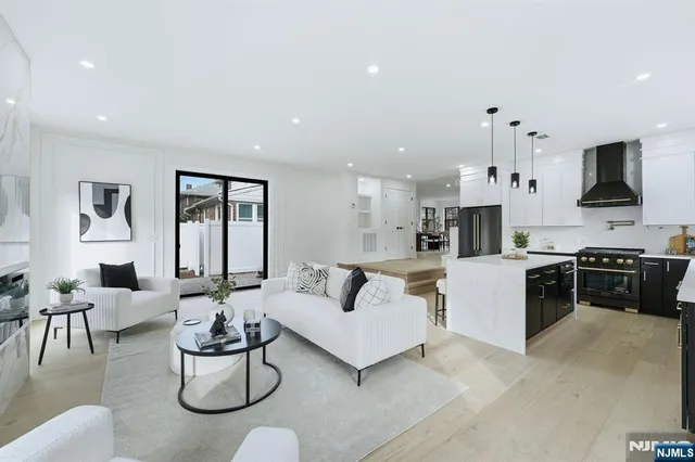 a living room with furniture kitchen view and a flat screen tv