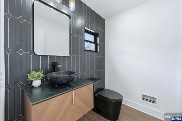 a kitchen with a sink and a stove with white cabinets