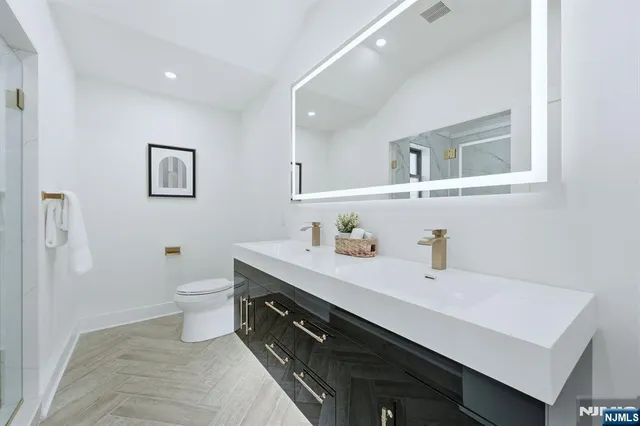 a bathroom with a sink a toilet and a mirror