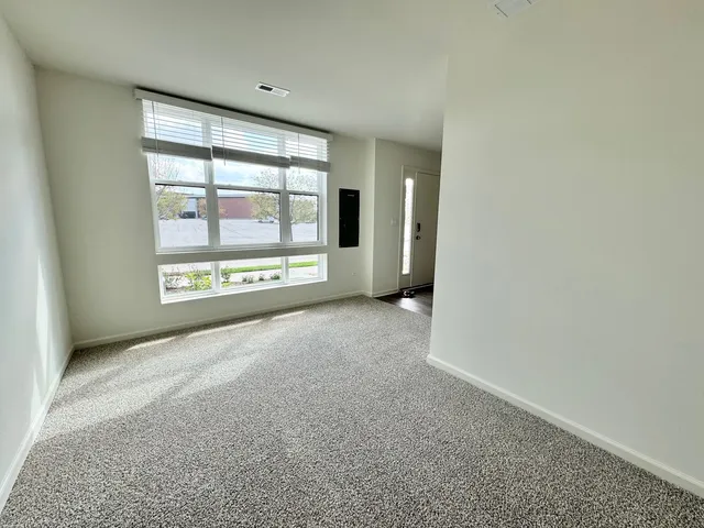 an empty room with a fireplace and windows