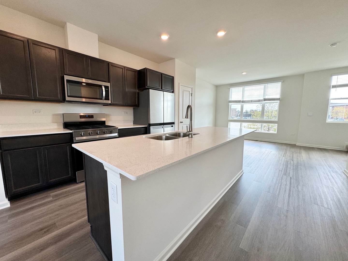 387 Summit Circle Lombard, IL 60148 - Photo 3 of 48 a kitchen with stainless steel appliances a sink a stove a microwave a center island and a window
