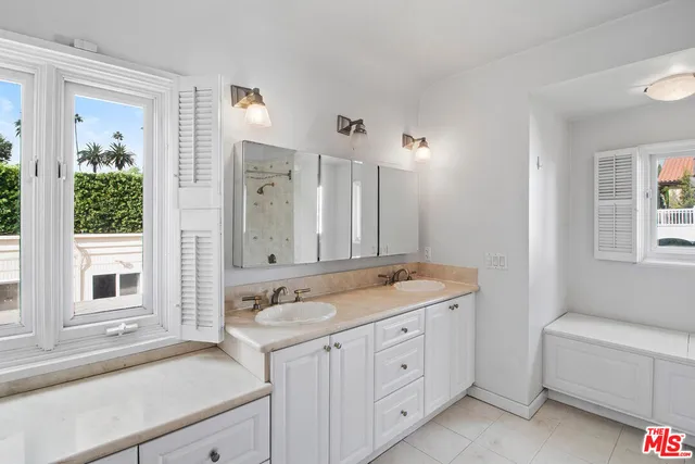 a spacious bathroom with a granite countertop sink and a mirror