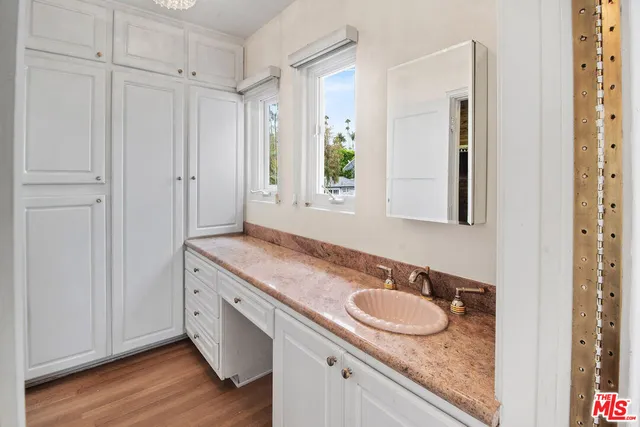 a bathroom with a granite countertop sink and a mirror
