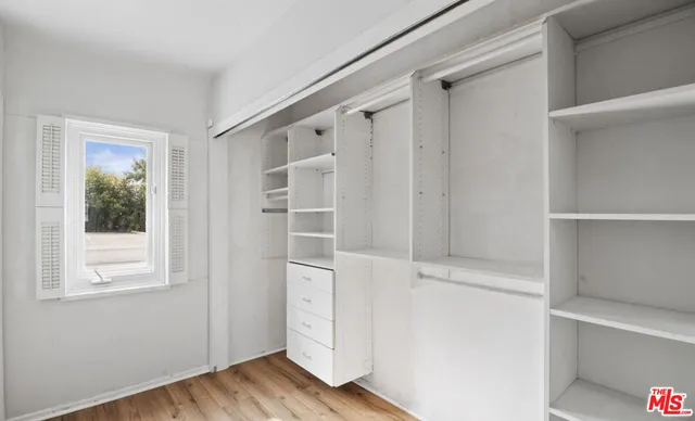 a view of walk in closet with empty racks