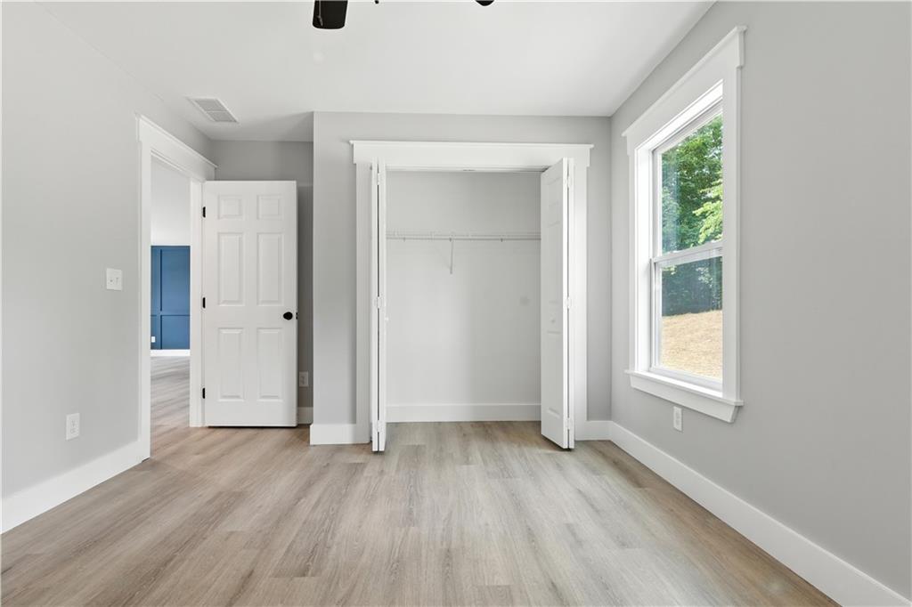 194 Harris Loop Dallas, GA 30157 - Photo 13 of 25 an empty room with wooden floor and windows