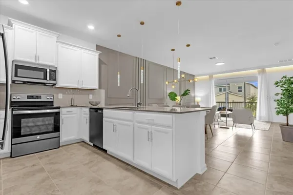 a kitchen with stainless steel appliances kitchen island granite countertop a stove a sink and a refrigerator