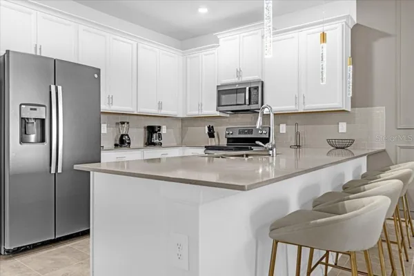 a kitchen with stainless steel appliances granite countertop a sink refrigerator and microwave