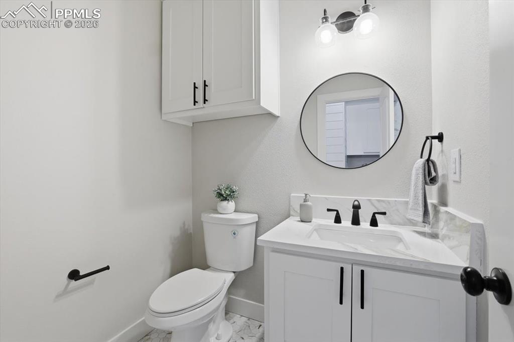 15755 Fool's Gold Lane Colorado Springs, CO 80921 - Photo 29 of 50 a bathroom with a toilet a sink and mirror