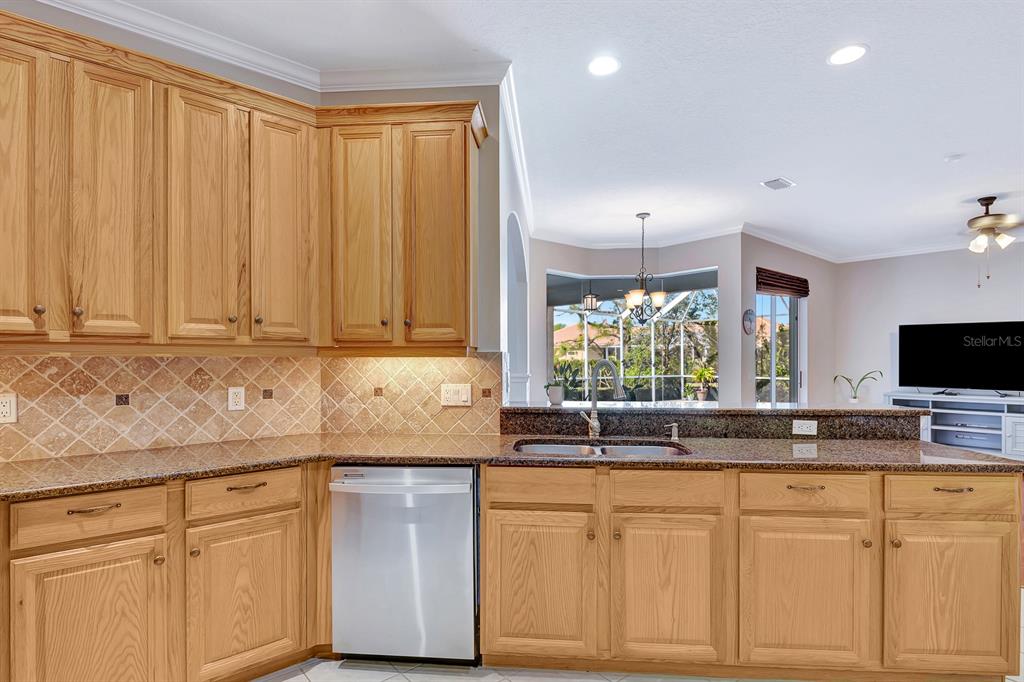 7344 Arrowhead Run Lakewood Ranch, FL 34202 - Photo 18 of 24 a kitchen with granite countertop white cabinets and white appliances