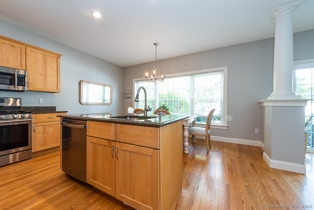 175 Ferry Road, Unit 3 Old Saybrook, CT 06475 - Photo 12 of 37 a kitchen with stainless steel appliances granite countertop wooden floors and white cabinets