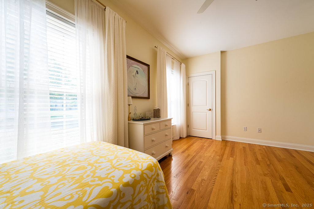 175 Ferry Road, Unit 3 Old Saybrook, CT 06475 - Photo 26 of 37 a bedroom with a bed and wooden floor