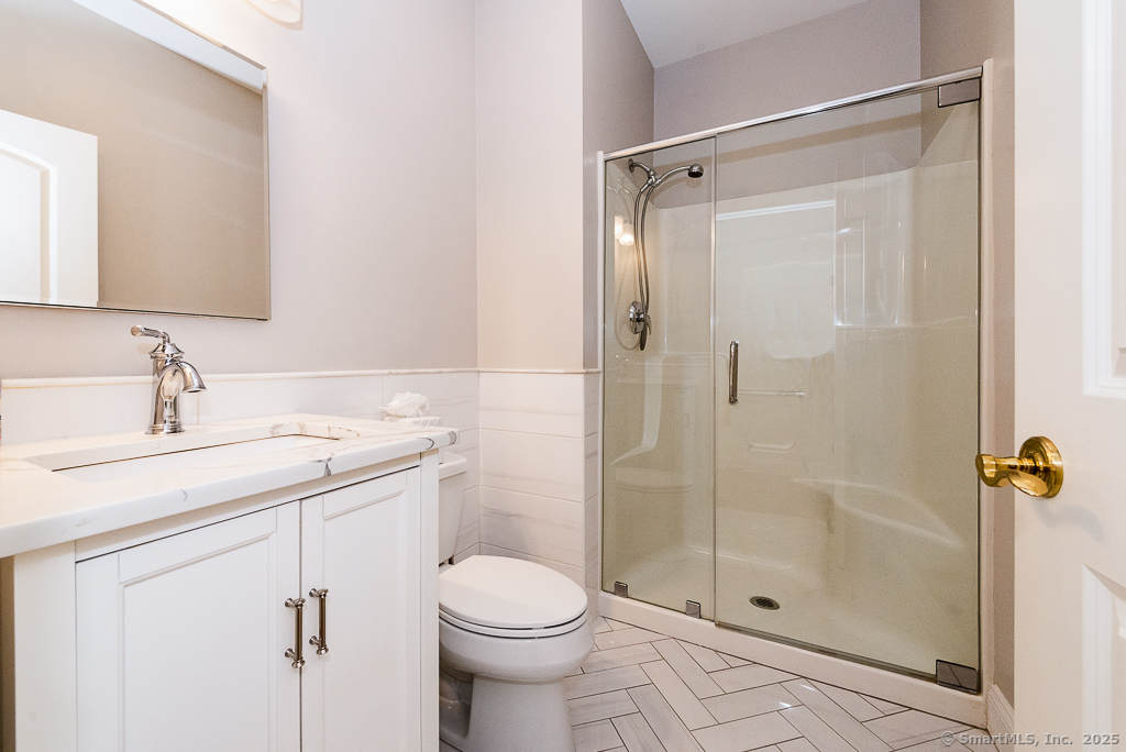 175 Ferry Road, Unit 3 Old Saybrook, CT 06475 - Photo 28 of 37 a bathroom with a shower sink vanity and toilet