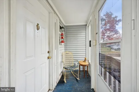 a view of a hallway with chairs and table in a room