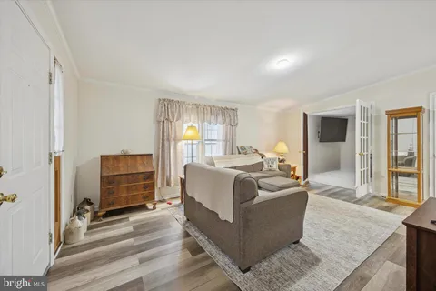 a spacious bedroom with a bed and wooden floor