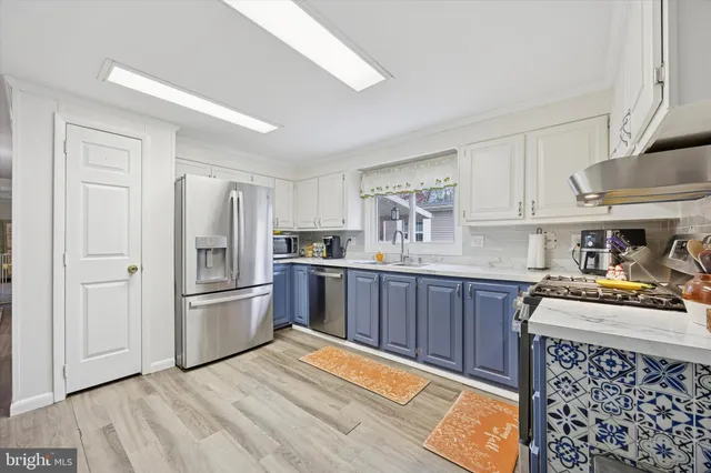 a kitchen with stainless steel appliances kitchen island granite countertop a refrigerator and a stove top oven