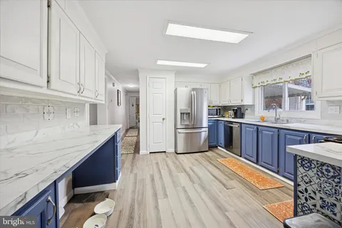 a kitchen with stainless steel appliances granite countertop a refrigerator sink and cabinets