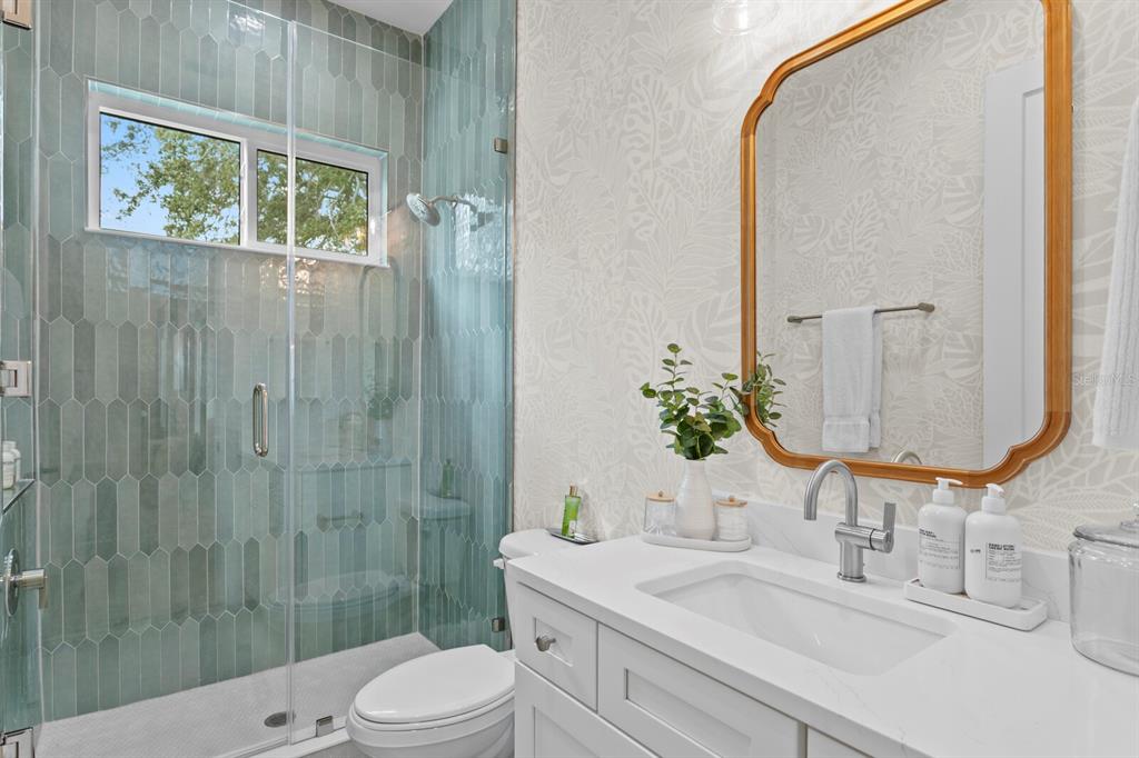 4807 West San Rafael Street Tampa, FL 33629 - Photo 29 of 64 a bathroom with a granite countertop sink a toilet and a mirror
