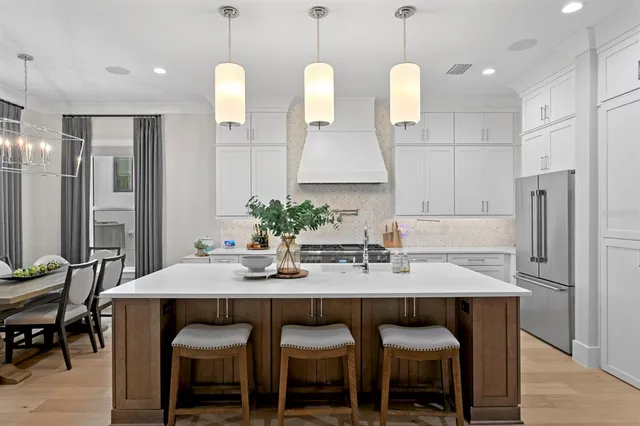 a kitchen with granite countertop a table chairs stove and refrigerator
