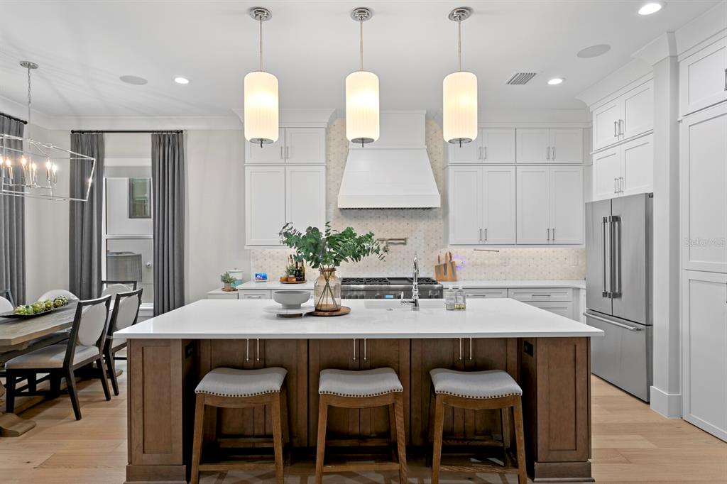 4807 West San Rafael Street Tampa, FL 33629 - Photo 4 of 64 a kitchen with granite countertop a table chairs stove and refrigerator