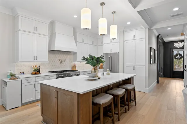 a kitchen with a sink stove and wooden floor