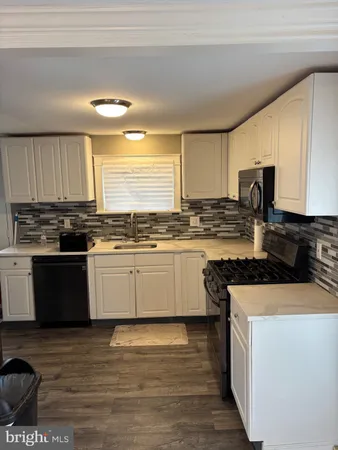 a kitchen with stainless steel appliances kitchen island granite countertop a stove a sink and a microwave