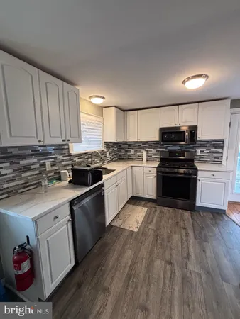 a kitchen with granite countertop a stove top oven and cabinets