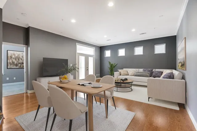 a living room with furniture a flat screen tv and a table