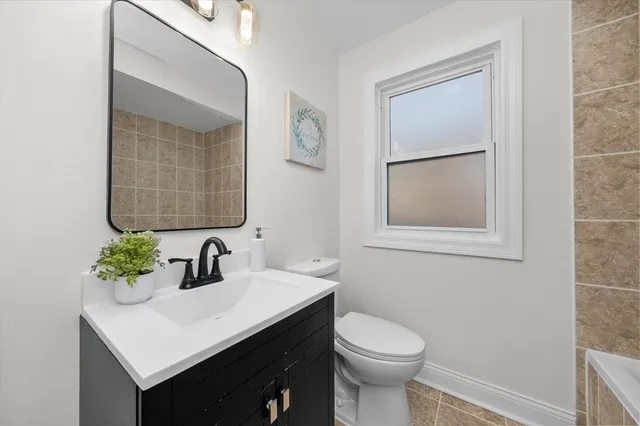 a bathroom with a sink vanity and a toilet