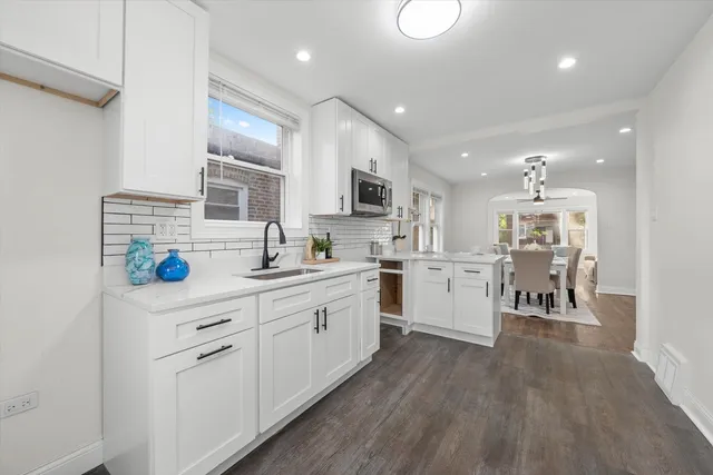 a kitchen with white cabinets and white appliances