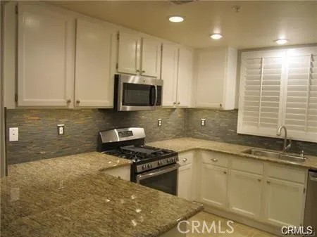 a bathroom with a granite countertop sink a mirror and a bathtub