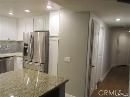 a bathroom with a granite countertop shower sink vanity and mirror