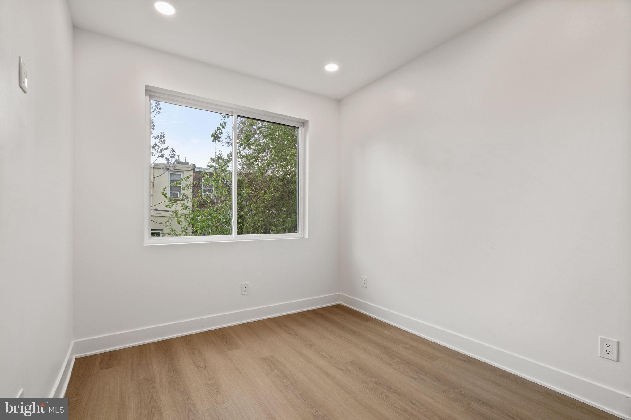 2410 Nicholas Street Philadelphia, PA 19121 - Photo 11 of 55 an empty room with wooden floor and windows