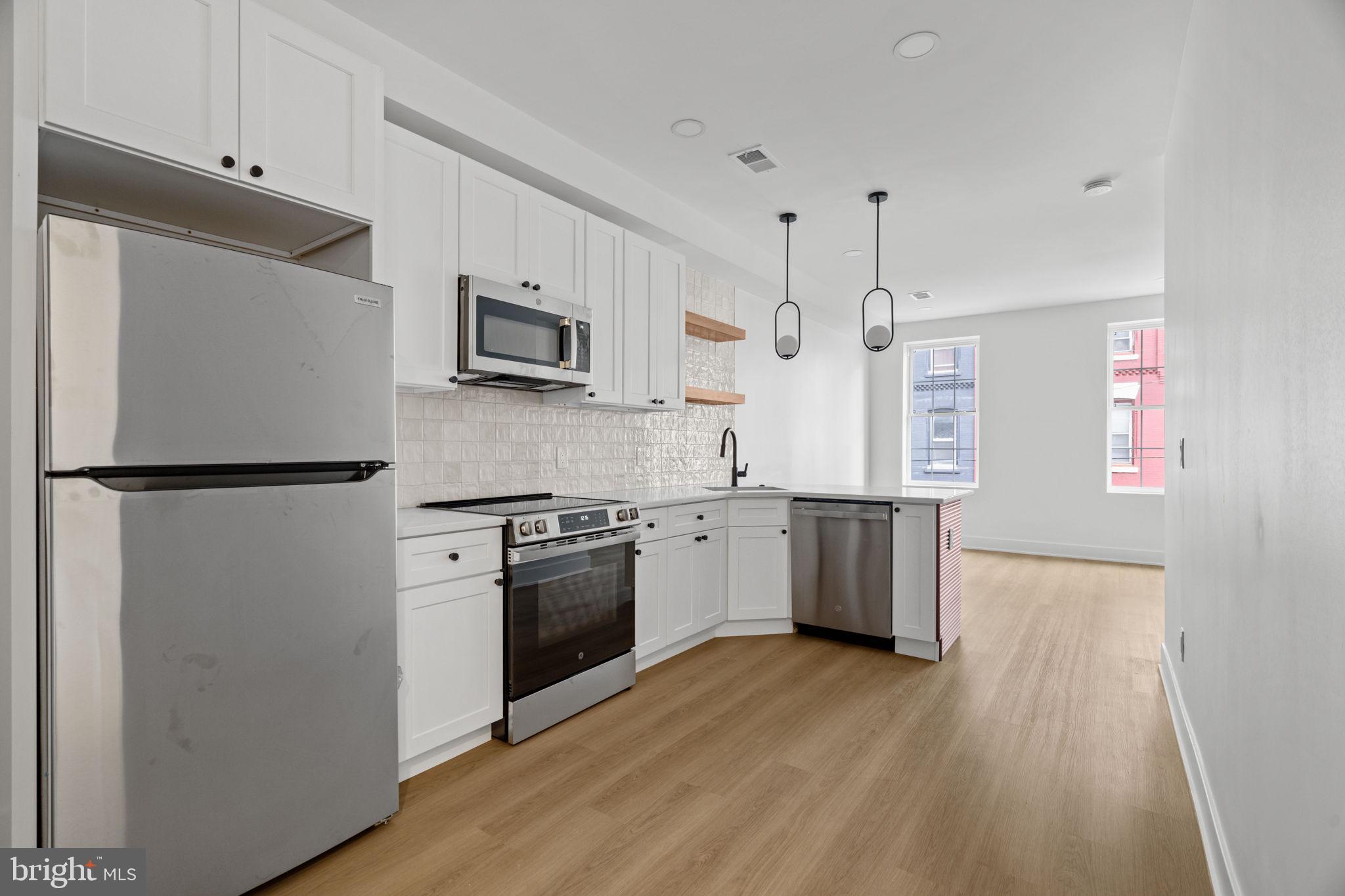 2410 Nicholas Street Philadelphia, PA 19121 - Photo 2 of 55 a kitchen with stainless steel appliances granite countertop a refrigerator a stove top oven a sink and dishwasher