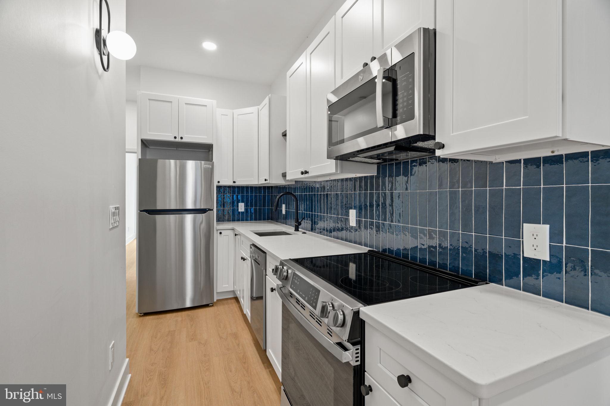 2410 Nicholas Street Philadelphia, PA 19121 - Photo 39 of 55 a kitchen that has a sink a refrigerator and a stove