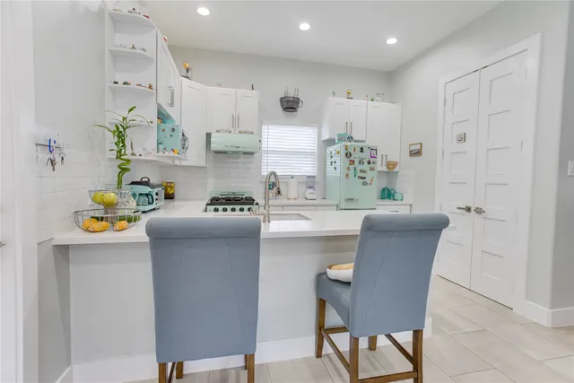 a kitchen with kitchen island stainless steel appliances a table and chairs in it