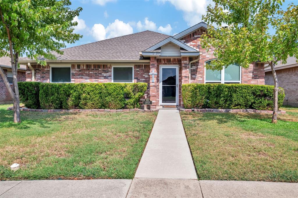 a front view of a house with a yard and potted plants