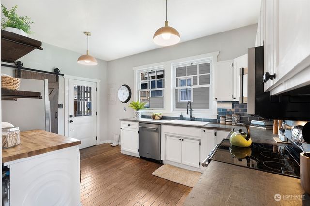 a kitchen with granite countertop a stove a sink a center island and windows